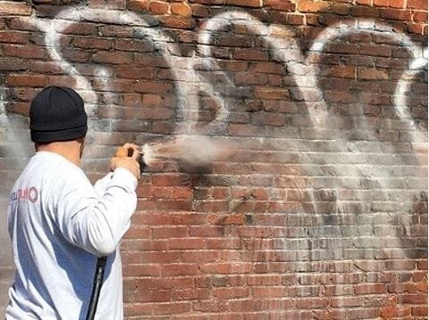 power washing graffiti off brick